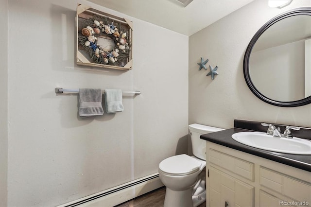 half bathroom featuring a baseboard heating unit, vanity, toilet, and wood finished floors