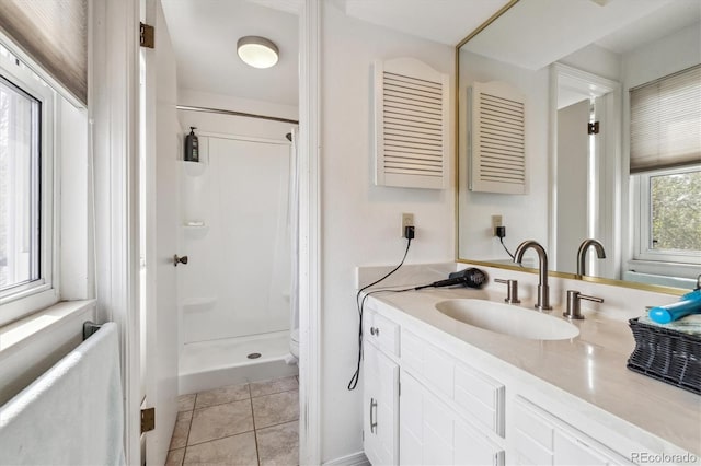 bathroom with a stall shower, vanity, and tile patterned floors