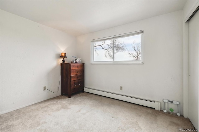 carpeted bedroom featuring a baseboard heating unit and a closet
