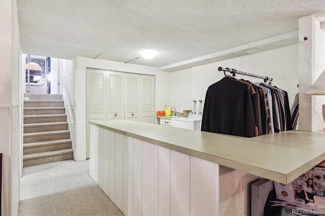 spacious closet featuring washer / dryer and light colored carpet
