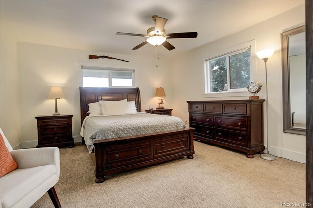 bedroom with light colored carpet, multiple windows, and ceiling fan