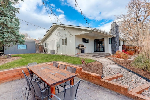 rear view of house featuring central AC unit, a patio area, and a lawn