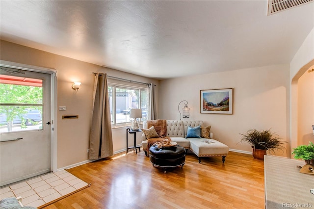 753 S Utica St, Denver, CO 80219 - living room with light wood-style floors, baseboards, and arched walkways
