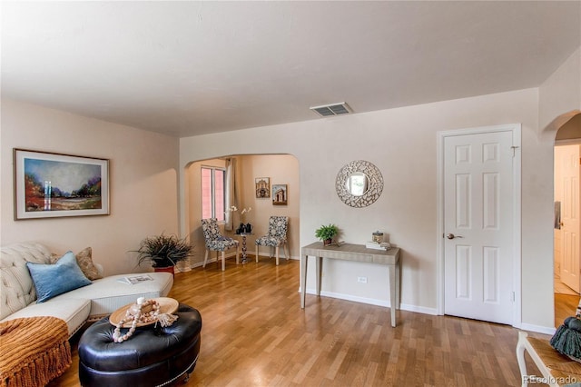 753 S Utica St, Denver, CO 80219 - living area featuring arched walkways, light wood-style flooring, and baseboards