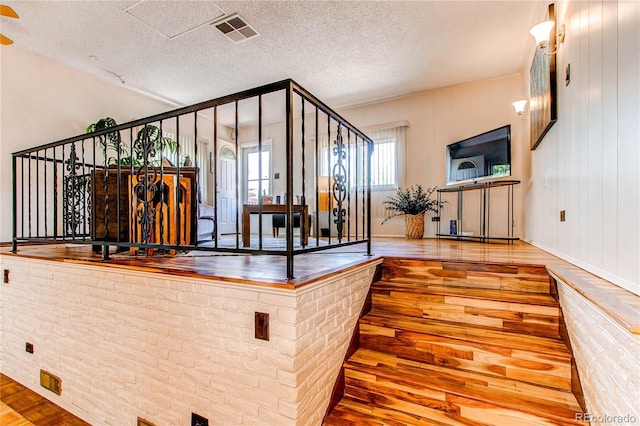 753 S Utica St, Denver, CO 80219 - stairway featuring wood finished floors, a textured ceiling, and baseboards