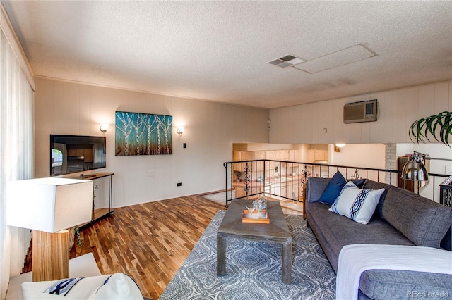 753 S Utica St, Denver, CO 80219 - living room with a textured ceiling, wood finished floors, and an AC wall unit