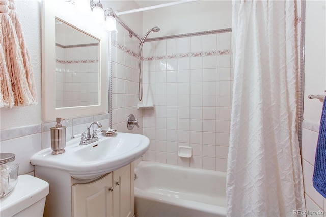 753 S Utica St, Denver, CO 80219 - full bathroom featuring toilet, shower / bath combo with shower curtain, vanity, and tile walls