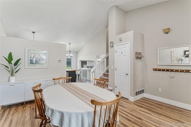 5102 S Lisbon Way, Centennial, CO 80015 - dining space featuring light wood-style floors, stairs, high vaulted ceiling, and a chandelier