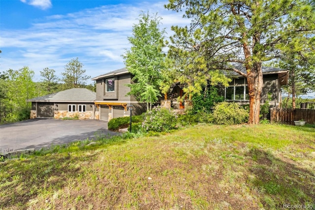 166 S Rainbow Trl, Evergreen, CO 80439 - obstructed view of property featuring asphalt driveway, a garage, and stone siding
