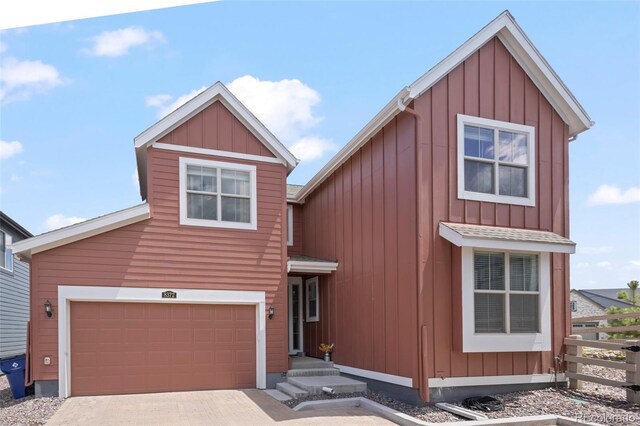 8372 Bijou Creek Ave, Littleton, CO 80125 - view of front of house featuring board and batten siding, fence, driveway, and an attached garage