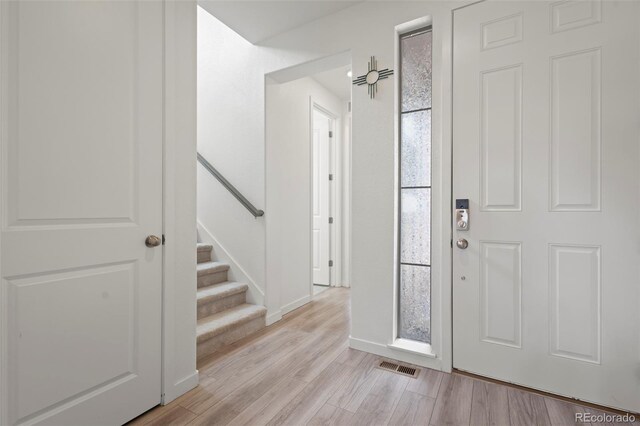 8372 Bijou Creek Ave, Littleton, CO 80125 - foyer featuring light wood-style flooring, baseboards, and stairway