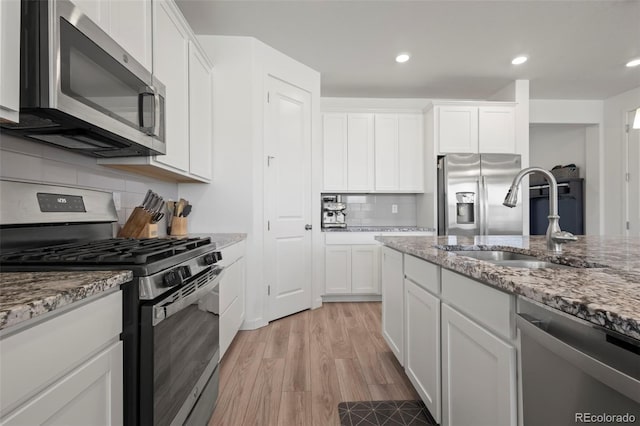 8372 Bijou Creek Ave, Littleton, CO 80125 - kitchen with appliances with stainless steel finishes, a sink, light stone counters, white cabinets, and recessed lighting