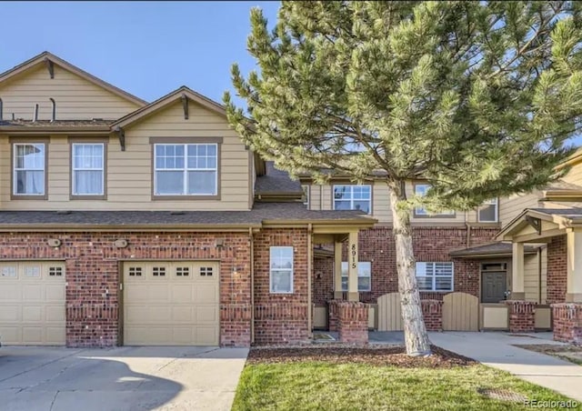 8915 Federal Blvd Unit 203, Westminster, CO 80260 - view of property with driveway, brick siding, a garage, and a shingled roof