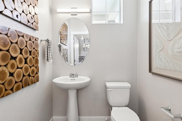 half bath with toilet and a sink