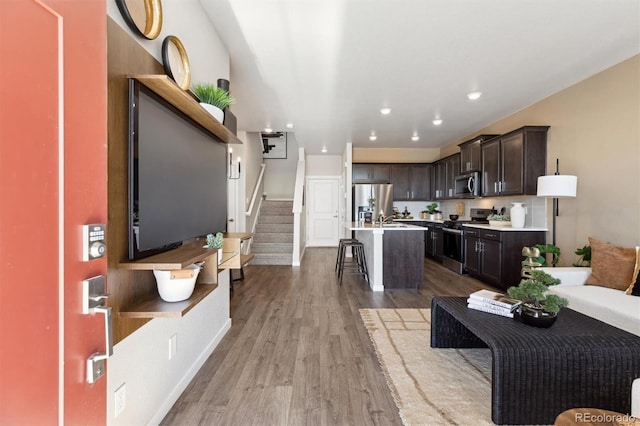 living room with wood finished floors, stairway, baseboards, and recessed lighting