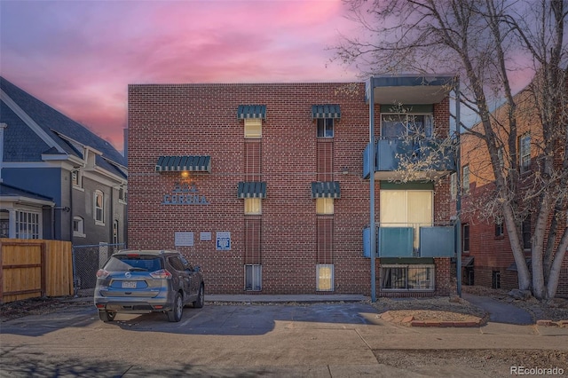 view of front of house with uncovered parking and fence