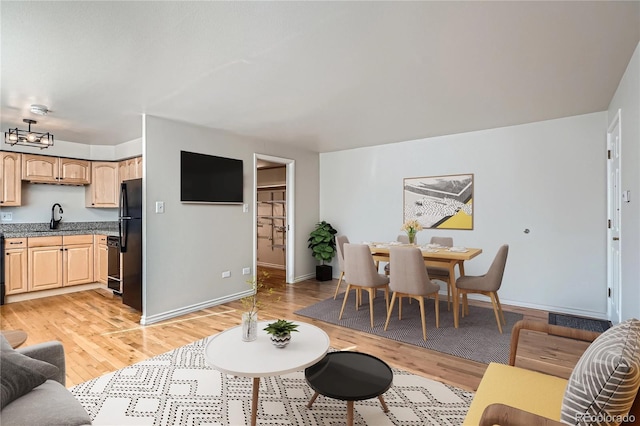 living area with baseboards and light wood-type flooring