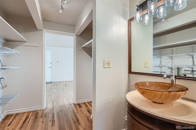 bathroom featuring vanity, baseboards, and wood finished floors