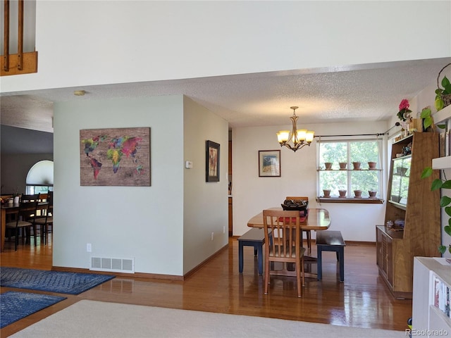 5695 W 109th Cir, Westminster, CO 80020 - dining area featuring a chandelier, wood finished floors, and a textured ceiling