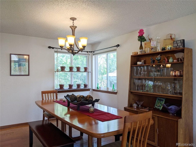 5695 W 109th Cir, Westminster, CO 80020 - dining space featuring a chandelier, a textured ceiling, and wood finished floors
