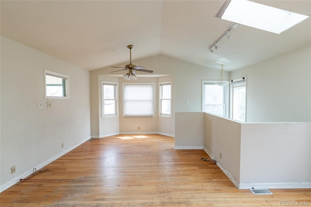 unfurnished room with plenty of natural light, lofted ceiling, and light wood-style flooring