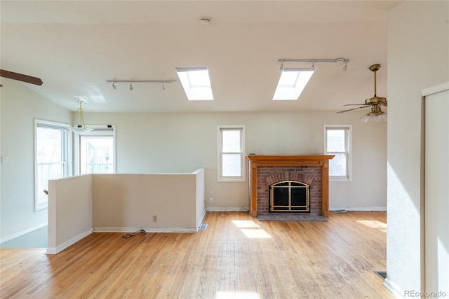 unfurnished living room with plenty of natural light, ceiling fan, and wood finished floors