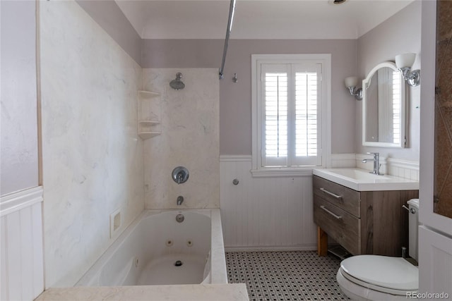 bathroom with vanity, toilet, wainscoting, and a combined bath / shower with jetted tub