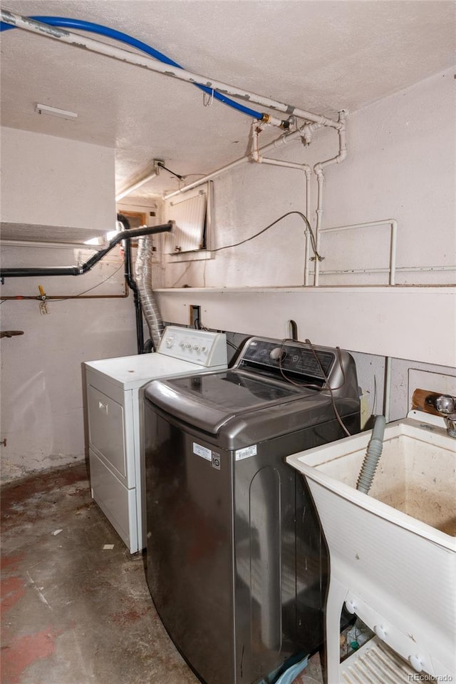 washroom with laundry area, independent washer and dryer, and a sink