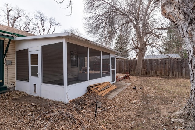 view of side of property with fence and a sunroom