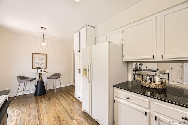 5016 S Nelson St Unit C, Littleton, CO 80127 - kitchen featuring white refrigerator with ice dispenser, white cabinetry, dark stone counters, light wood-style floors, and pendant lighting