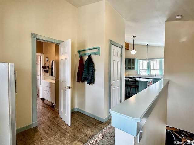 kitchen featuring hardwood / wood-style floors, lofted ceiling, kitchen peninsula, and hanging light fixtures