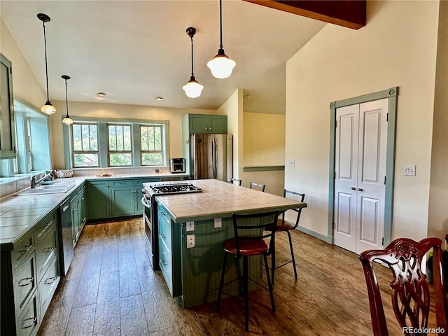 kitchen with dark wood-type flooring, sink, hanging light fixtures, vaulted ceiling with beams, and stainless steel appliances