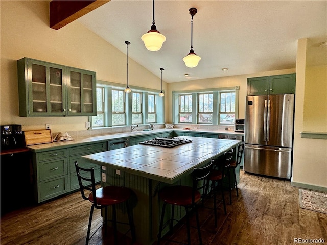 kitchen featuring a breakfast bar, stainless steel appliances, a wealth of natural light, and dark wood-type flooring