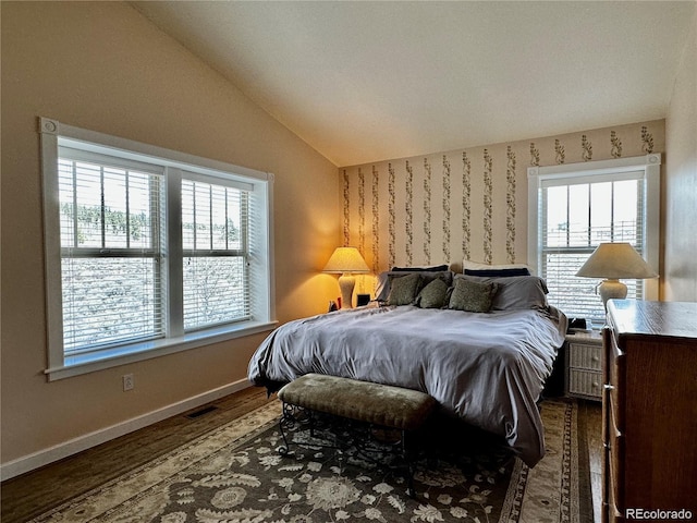 bedroom with hardwood / wood-style flooring, multiple windows, and lofted ceiling