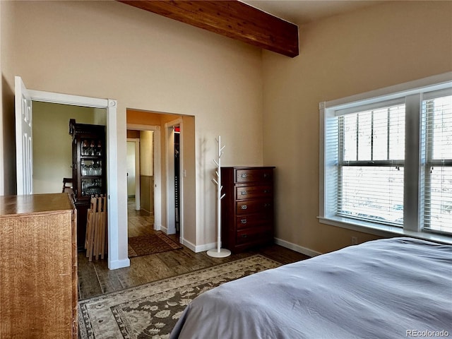 bedroom featuring beam ceiling and dark hardwood / wood-style floors