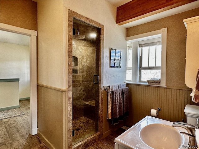 bathroom with hardwood / wood-style floors, vanity, a shower with shower door, and toilet