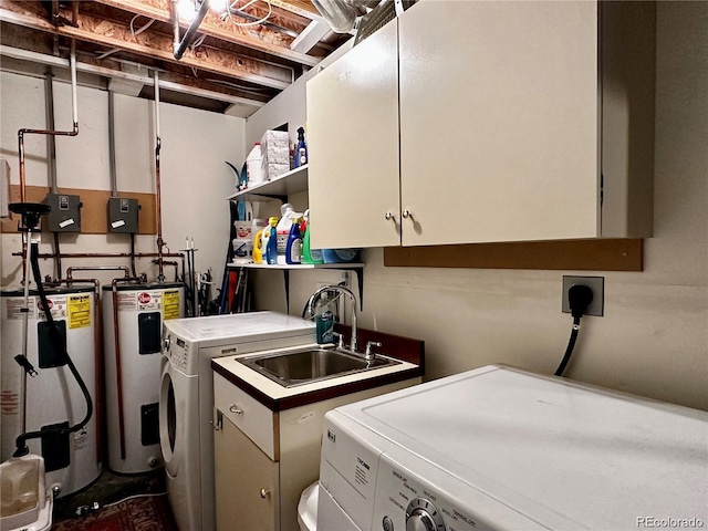 laundry area featuring sink, cabinets, gas water heater, water heater, and washer and clothes dryer