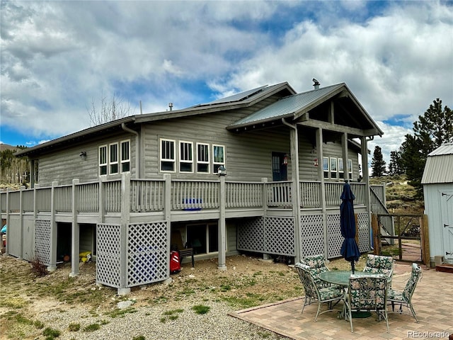 back of property with a patio area and a storage shed