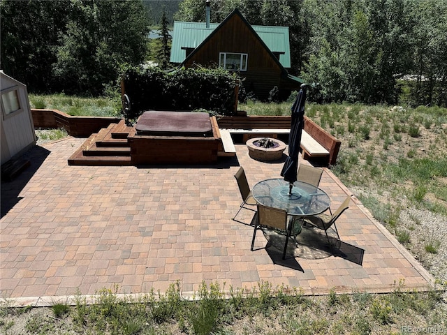 view of patio featuring a hot tub and an outdoor fire pit