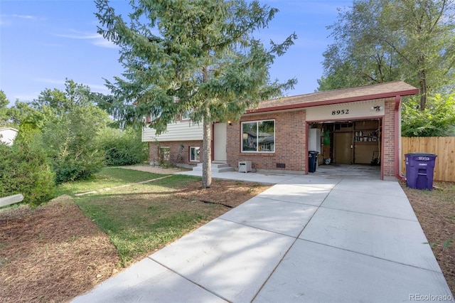 tri-level home with concrete driveway, brick siding, fence, and an attached garage