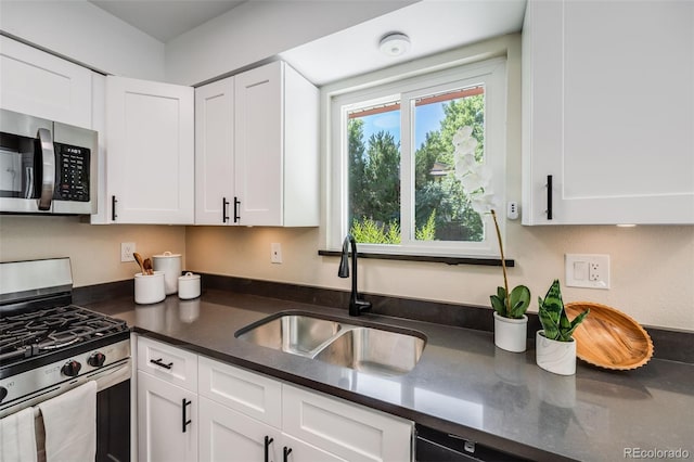 kitchen with stainless steel appliances, a sink, and white cabinets