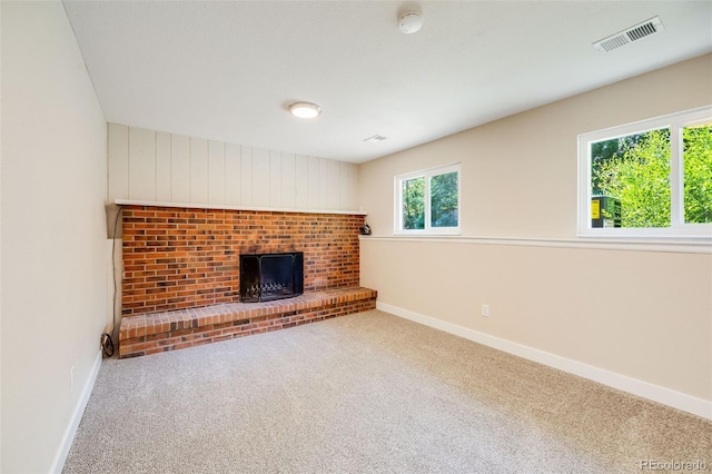 unfurnished living room with carpet floors, baseboards, a fireplace, and visible vents