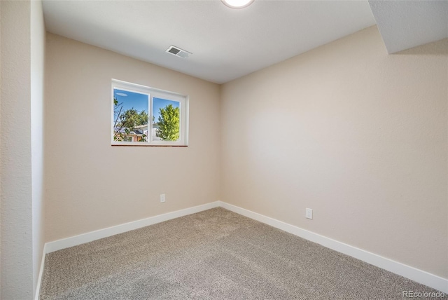 carpeted spare room with visible vents and baseboards