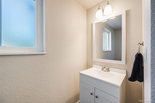 bathroom with a textured wall and vanity