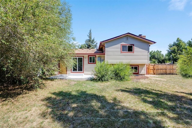 back of property featuring a yard, a patio area, and fence