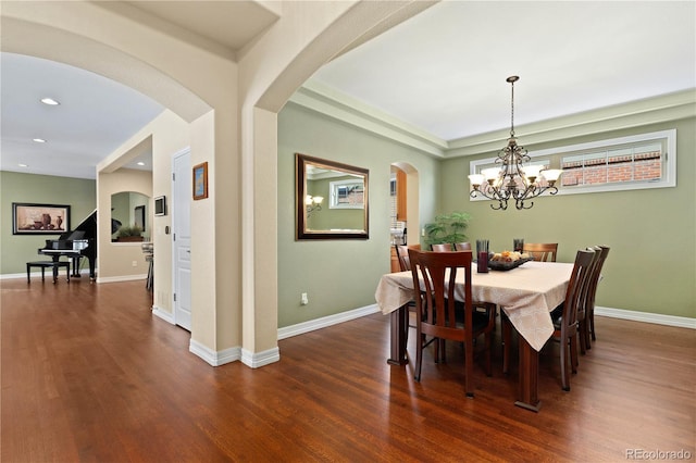 dining area featuring dark wood-style floors, recessed lighting, arched walkways, and baseboards