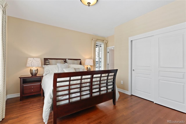 bedroom with a closet, baseboards, and wood finished floors