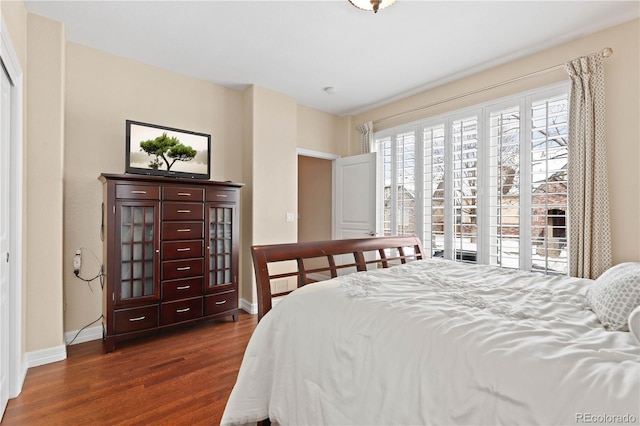 bedroom with dark wood-style floors and baseboards