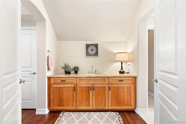 bathroom featuring wood finished floors, vanity, and baseboards