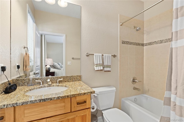 full bathroom featuring shower / tub combo, a textured wall, vanity, and toilet